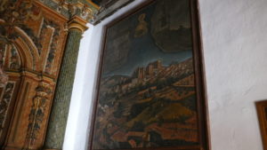 Painting that portrays the location of the Basilica in relation to the rural area and mountains.