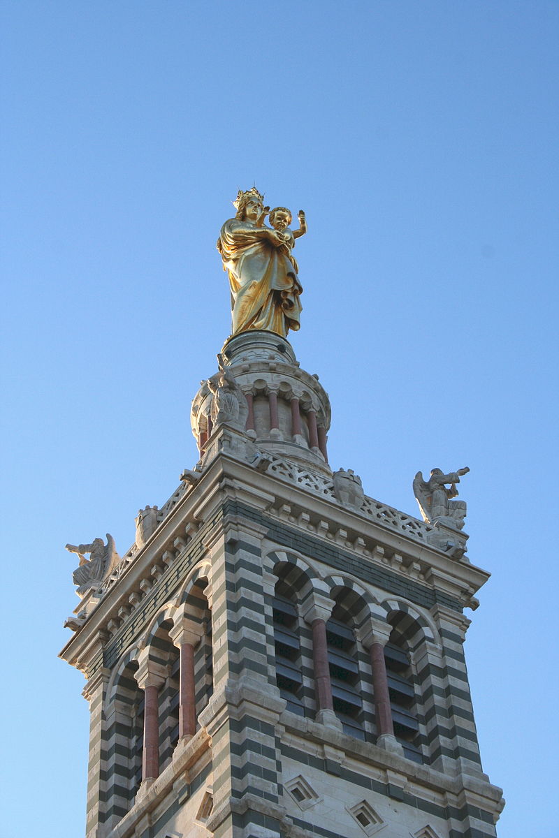 Color photo of the gold gilded 30' statue of the Madonna as it looks today perched at the top of the Basicila.