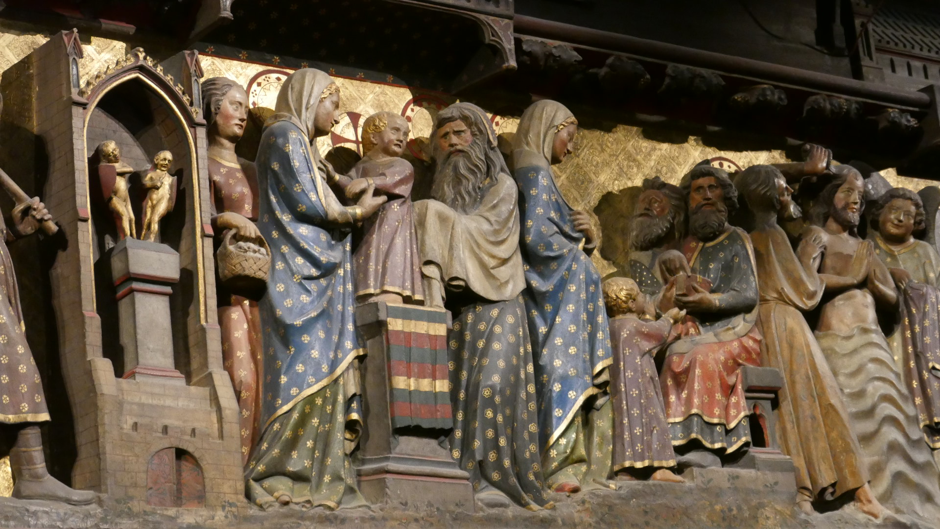 Photo of Close up view of a scene in the Life of the Virgin Mary with Baby Jesus at the Temple and (I believe) St. Simon the Elder at the 40 day presentation of Jesus at the temple on one of the 2 giant wooden carvings.