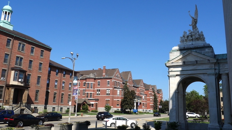 Photo of one block of campus buildings across the street from the OLV Basilica