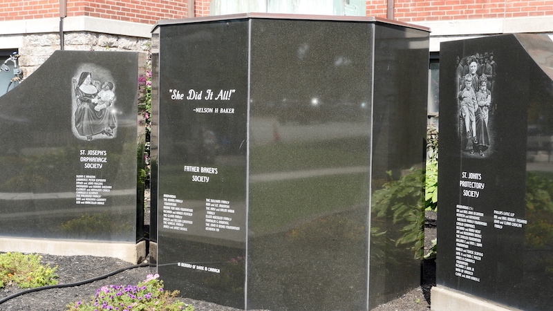 Photo of black marble statue in park with the words "She Did It All!"