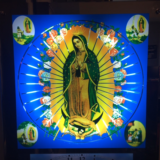 A display of Our Lady of Guadalupe who is in the center plus in each corner is an oval with Juan Diego speaking with her at various times.