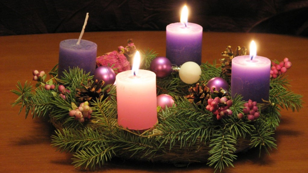 picture of 3 advent candles lit on an evergreen wreath