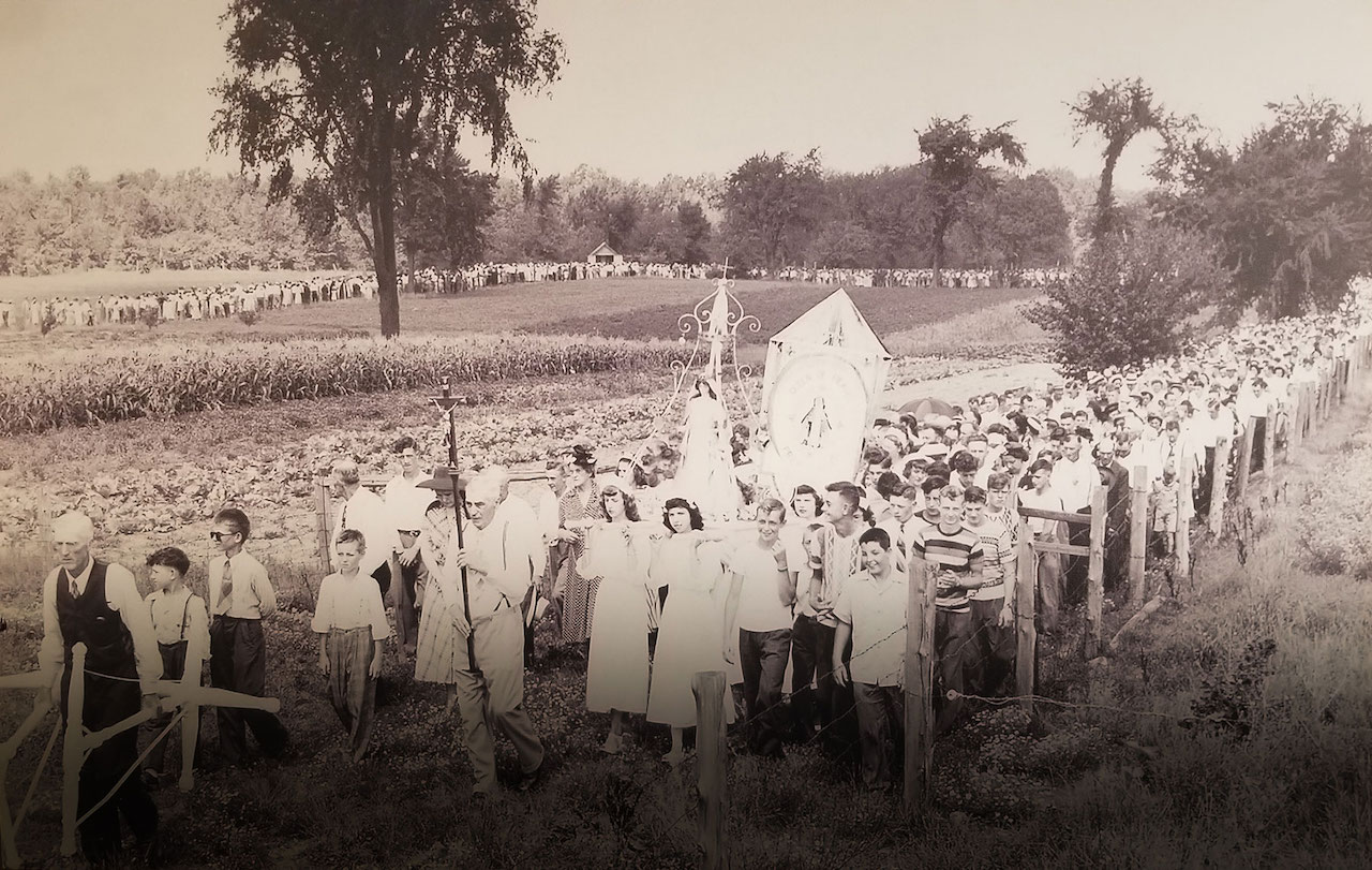 A black and white picture of a huge procession of children on the grounds of Our Lady of Good Hope also known as The Shrine of Our Lady of Champion, near Green Bay Wisconsin. The date is unknown, but guessing by the attire of the children it was taken in the late 1950's