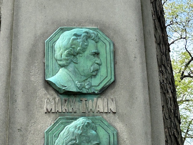 Close up of Mark Twain in profile on the monument with his name underneath.