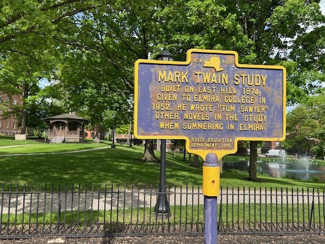 Wider shot to include a historical marker in the foreground with the Mark Twain study seen behind it as currently located on the Elmira College campus.
